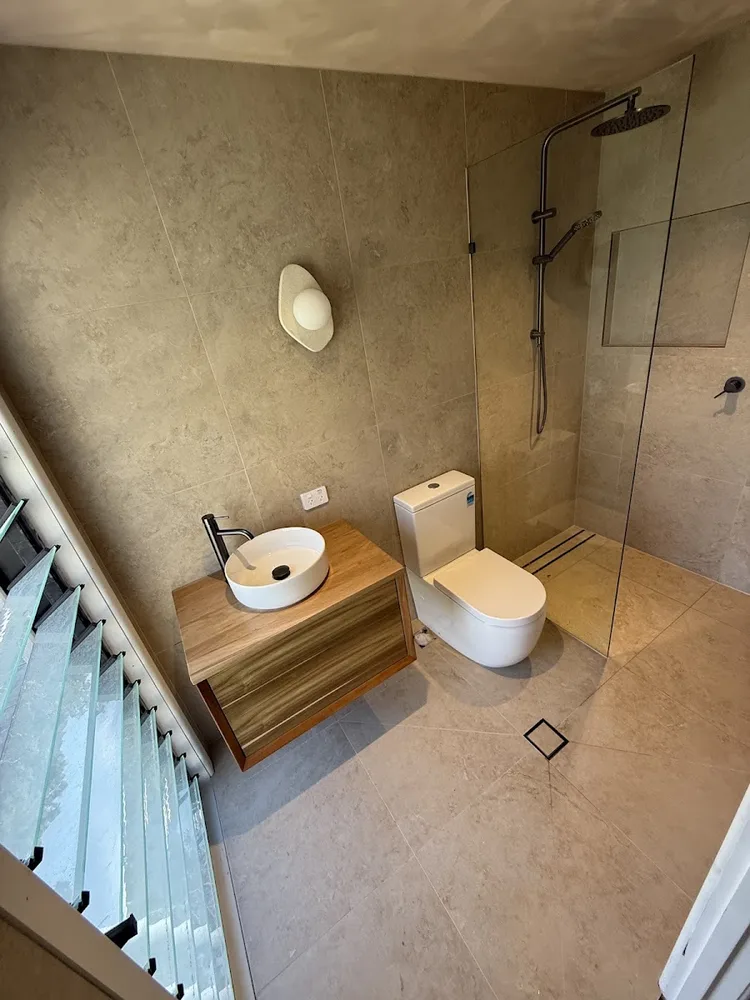 Renovated home bathroom with new toilet, basin and shower by Walter & Co