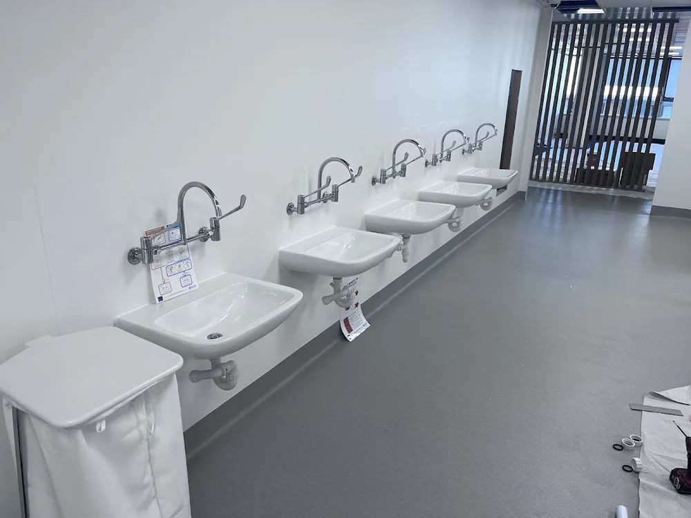 Commercial washroom fit-out with row of basins by Walter & Co