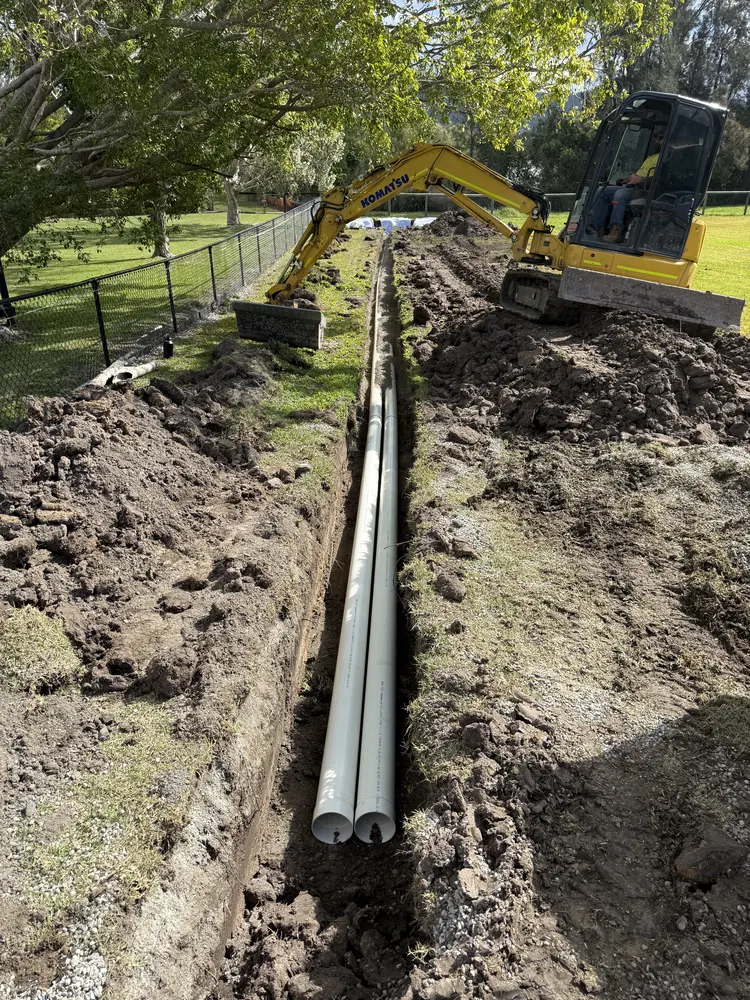 Excavator digging a subsoil drainage trench at Oxenford on the Gold Coast