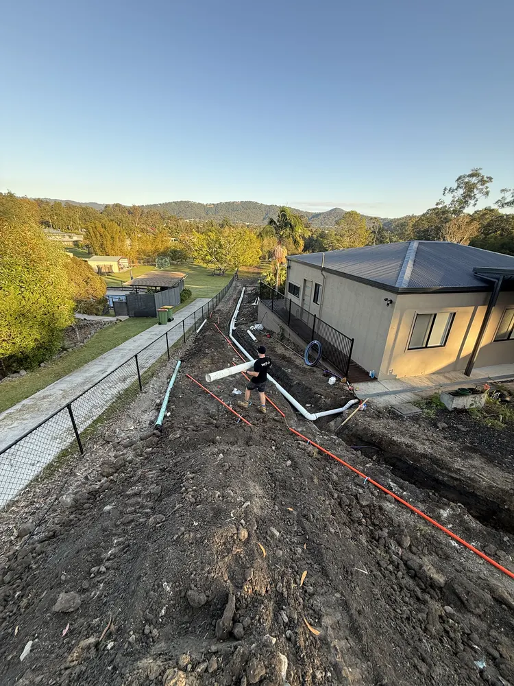 Graded drainage trench line running beside the house